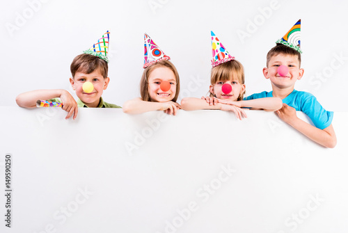 happy children with holiday decorations and advertisement blank in front of them