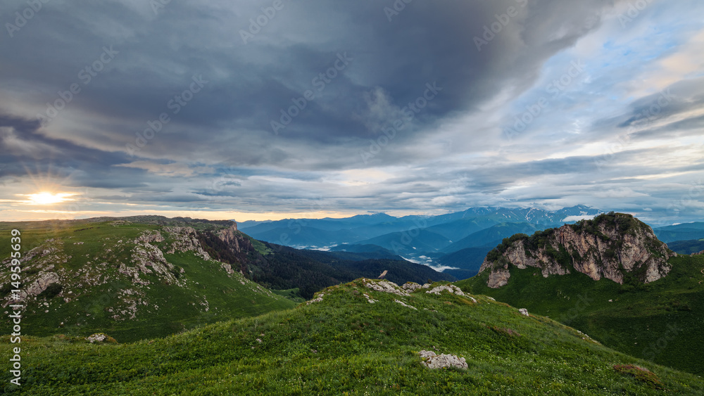 Mountain valleys and alpine meadows at sunset with cloudy sky. Lagonaki, Caucasus, Russia