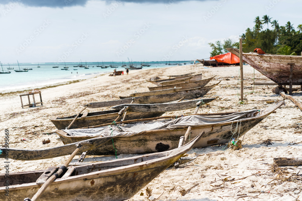 many old wooden fishing boats on african seashore with ocean on the background many old wooden fishing boats on african seashore with ocean on the background