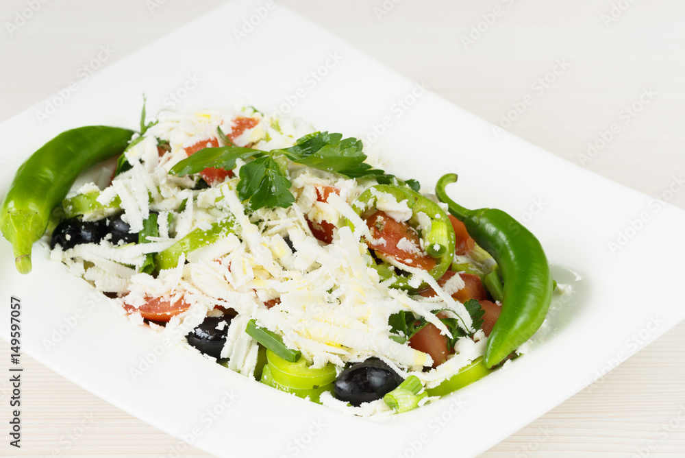 Traditional classic Shopska salad with tomatoes, peppers, cucumbers and cheese in white dish on white wooden table. Bulgarian cuisine, Balkan culture Traditional classic Shopska salad with tomatoes, peppers, cucumbers and cheese in white dish on white wooden table. Bulgarian cuisine, Balkan culture