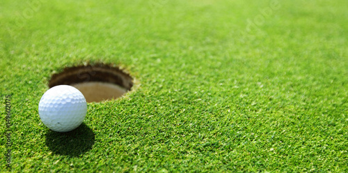 Fototapeta golf ball on lip of cup