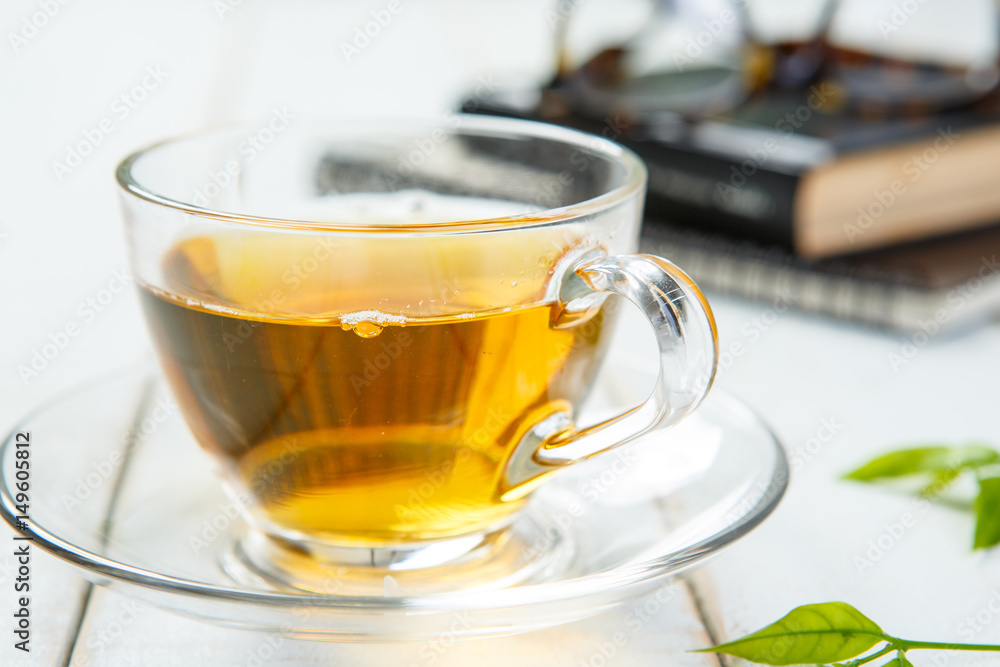 Cup of tea and book on white wooden table