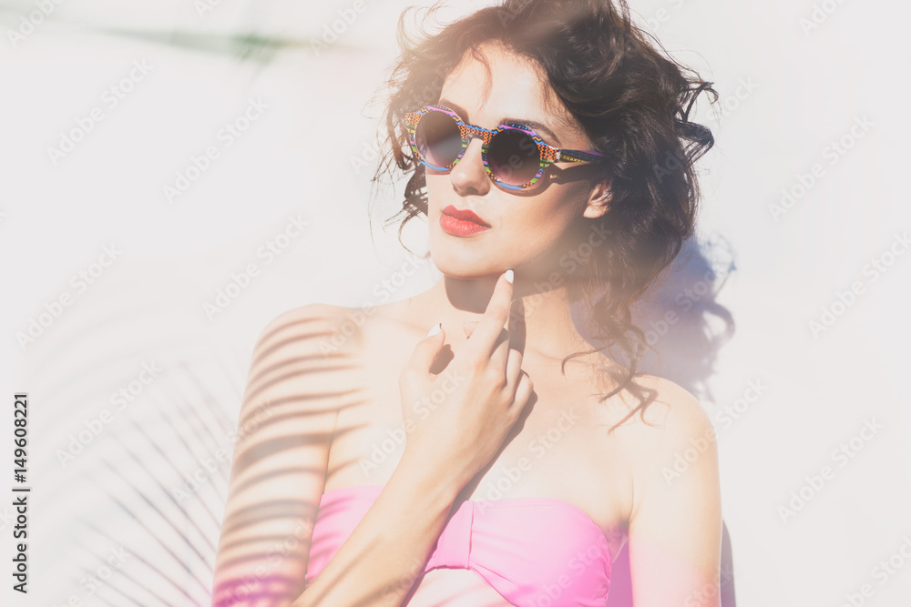 Summer style portrait of young attractive woman wearing sunglasses. Tropical holiday fashion beauty concept Summer style portrait of young attractive woman wearing sunglasses. Tropical holiday fashion beauty concept