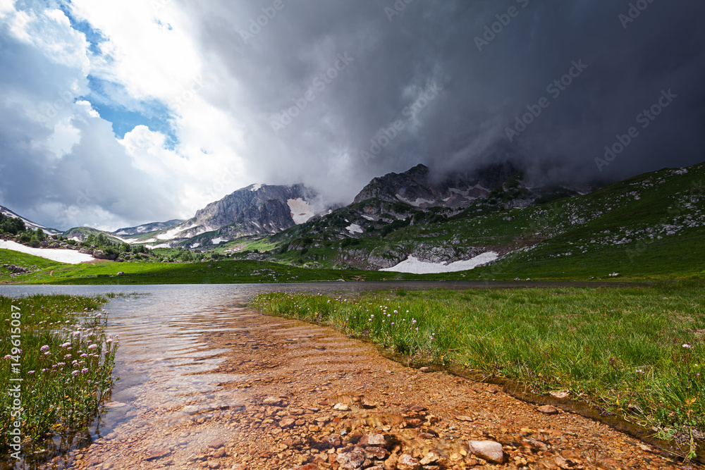 Mountain landscape with Pshekha-su mountain in gloomy cloud and Psenodah lake in the valley of Lagonaki, Caucasus, Russia