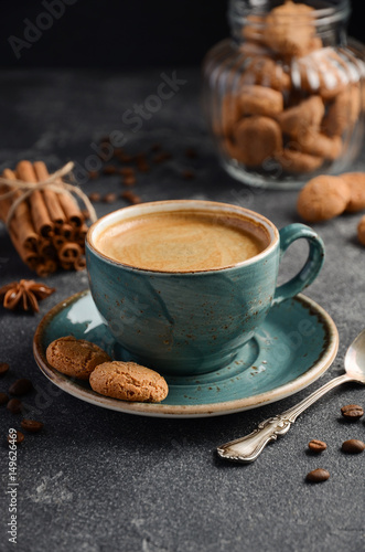 Cup of fresh coffee with Amaretti cookies on dark background, selective focus