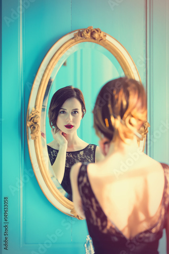 Canvas Print young woman looking at mirror