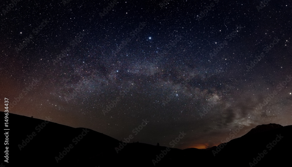 Starry sky with Milky way and silhouette of mountains Starry sky with Milky way and silhouette of mountains