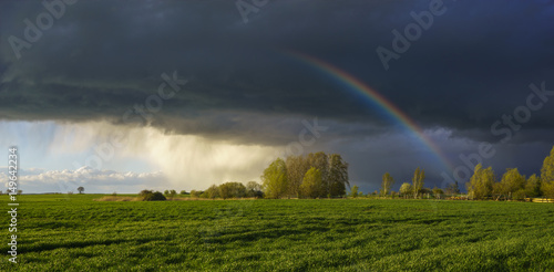 Rainbow in the sky above the spring field after the storm © Mike Mareen