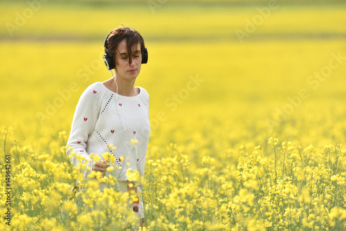 Caucasian girl listening to music with headphone in the outdoors
