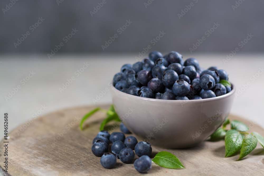 Freshly picked juicy blueberries with green leaves on rustic table. Bilberry on wooden Background. Blueberry antioxidant. Concept for healthy eating and nutrition Freshly picked juicy blueberries with green leaves on rustic table. Bilberry on wooden Background. Blueberry antioxidant. Concept for healthy eating and nutrition