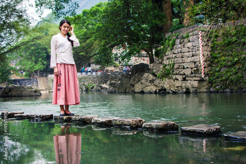 Girl walking on the stone bridge in the river © creativefamily