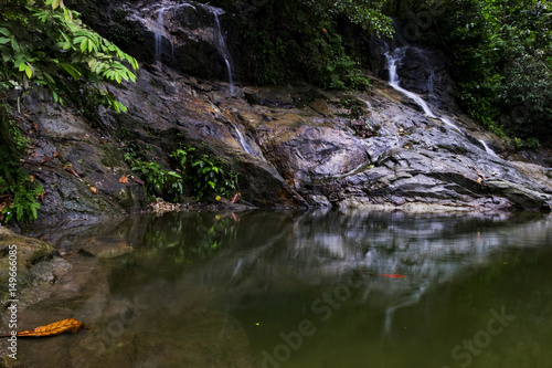 tropical nature background, waterfall stream and beutiful reflection on the pond