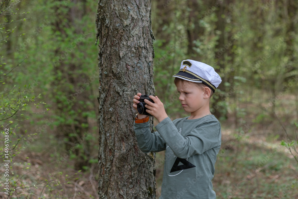 Young photographer in a pine forest with a camera Young photographer in a pine forest with a camera