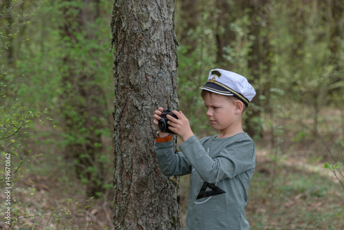 Young photographer in a pine forest with a camera