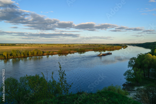 Fototapeta Naklejka Na Ścianę i Meble -  Spring landscape with a view of the bend in the river and a cargo barge
