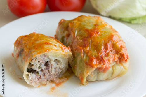 Cabbage rolls on a white plate and ingredients. Tasty dish.
