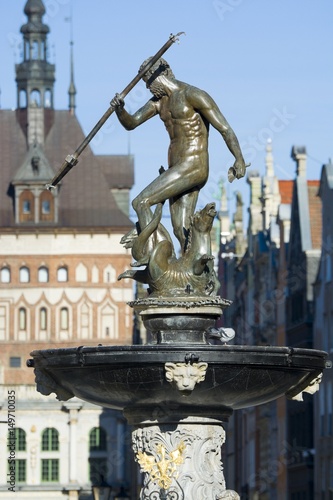 Neptune Fountain - symbol of Gdansk, located at Long Market, blurred Prison Tower and Golden Gate in the background, Poland