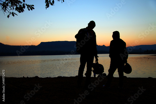 Two Young man standing nearby lake in holiday morning