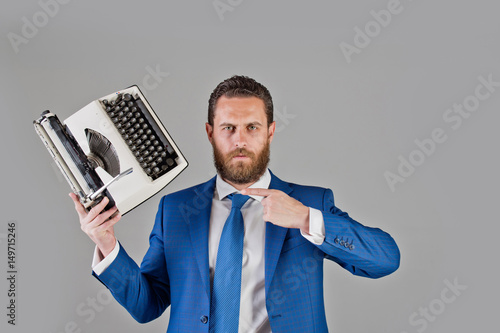 business man in blue suit and tie with typewriter