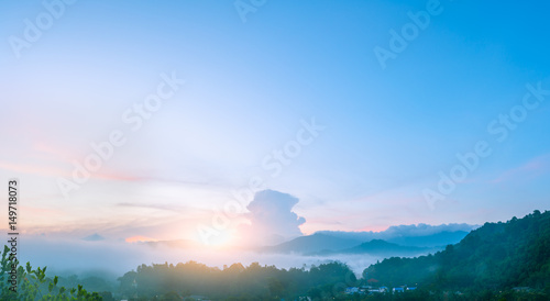 Panorama landscape view of sunrise sky with fog amidst small countryside village .in nutrural forest and mountains at Ranong province, Southern of Thailand
