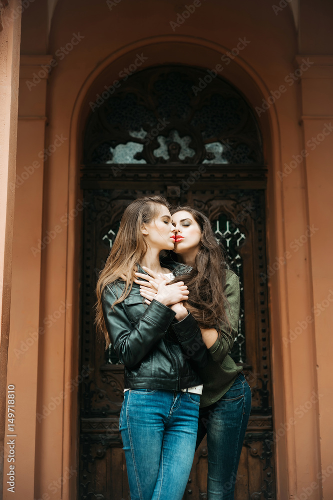 pretty girls kissing and hugging in jeans on front door Stock Photo | Adobe  Stock