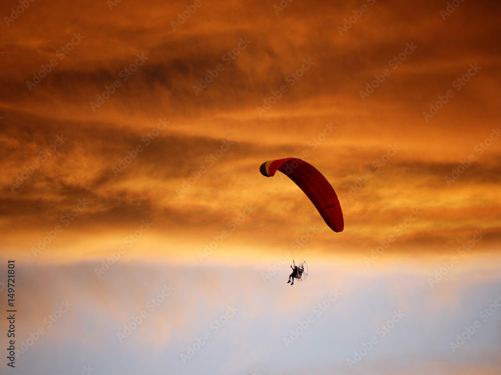 Paramotor flying in the sunset sky, Silhouette shot. Paramotor flying in the sunset sky, Silhouette shot.