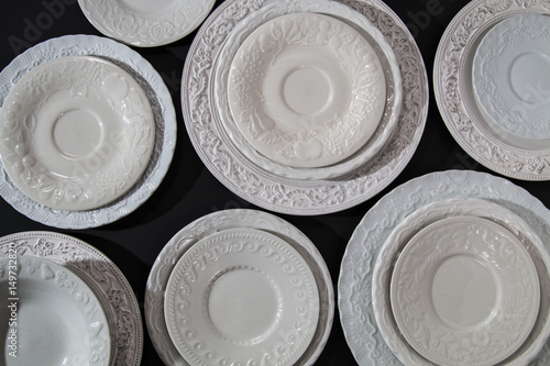 Set of white ceramic relief plates on background