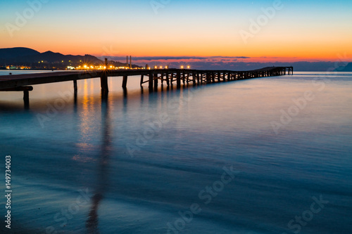Sunset on a sandy beach and a wooden pier, Panorama © luchschenF