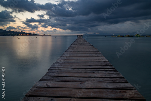 Sunset on a sandy beach and a wooden pier, Panorama