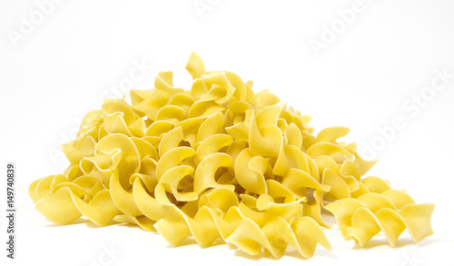 Mound of uncooked yellow egg noodles. Isolated.