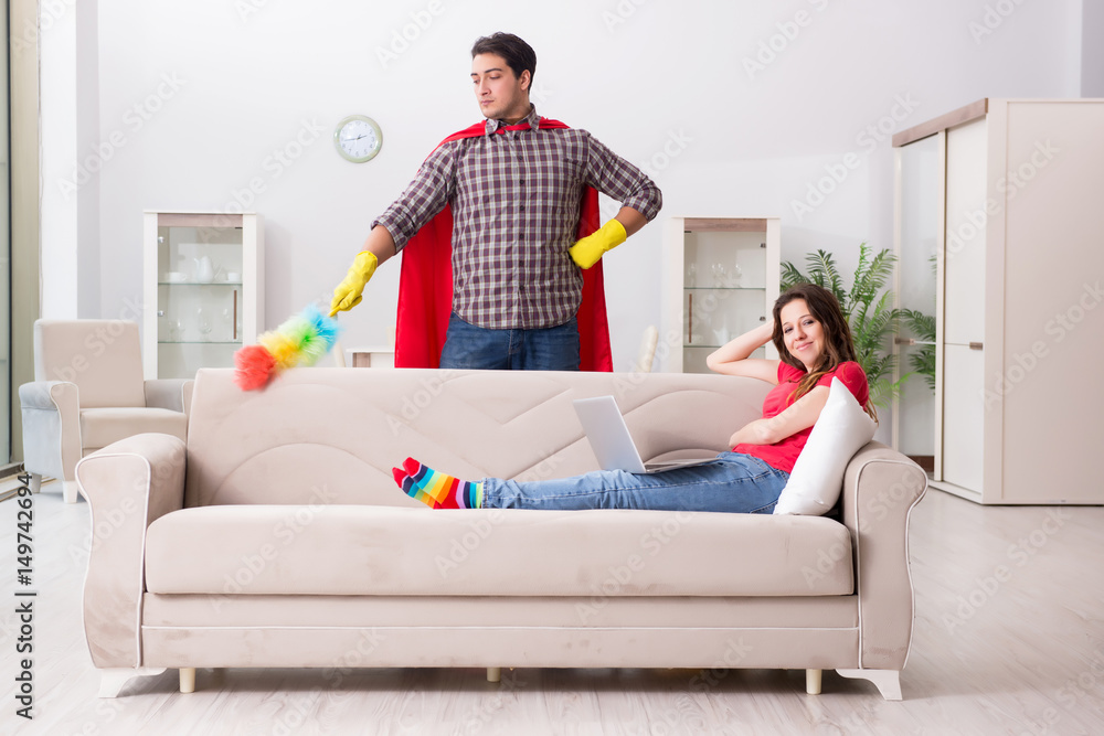 Obraz premium Superhero husband helping his wife at home