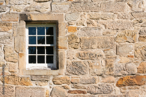 old style paned glass window set in stone wall