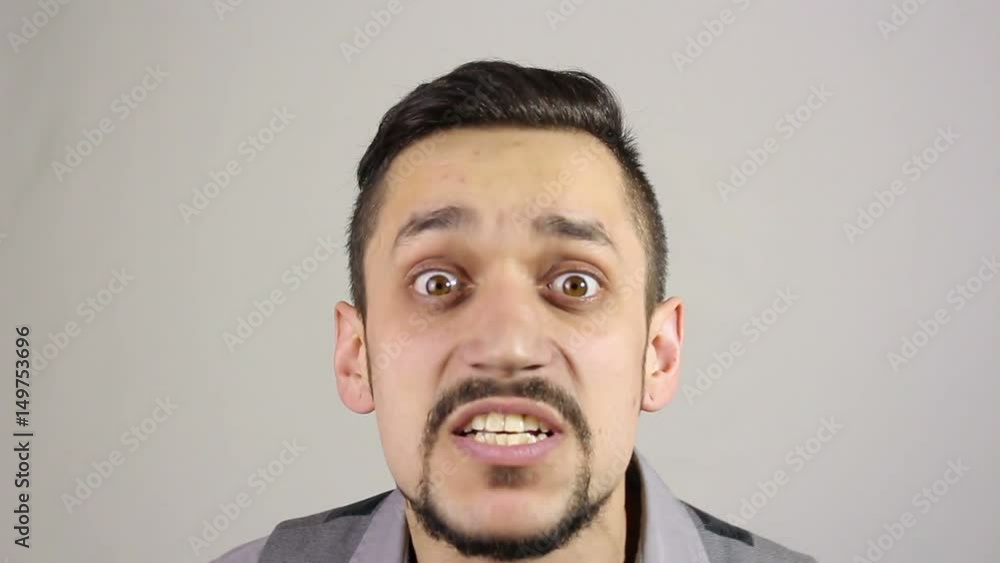 Close up of young adult man full of fury, looking at the camera. Swears Close up of young adult man full of fury, looking at the camera. Swears