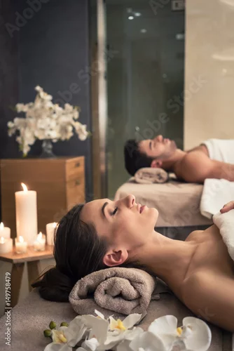 Obraz Mężczyzna i kobieta, leżąc na łóżkach do masażu w azjatyckim centrum odnowy biologicznej