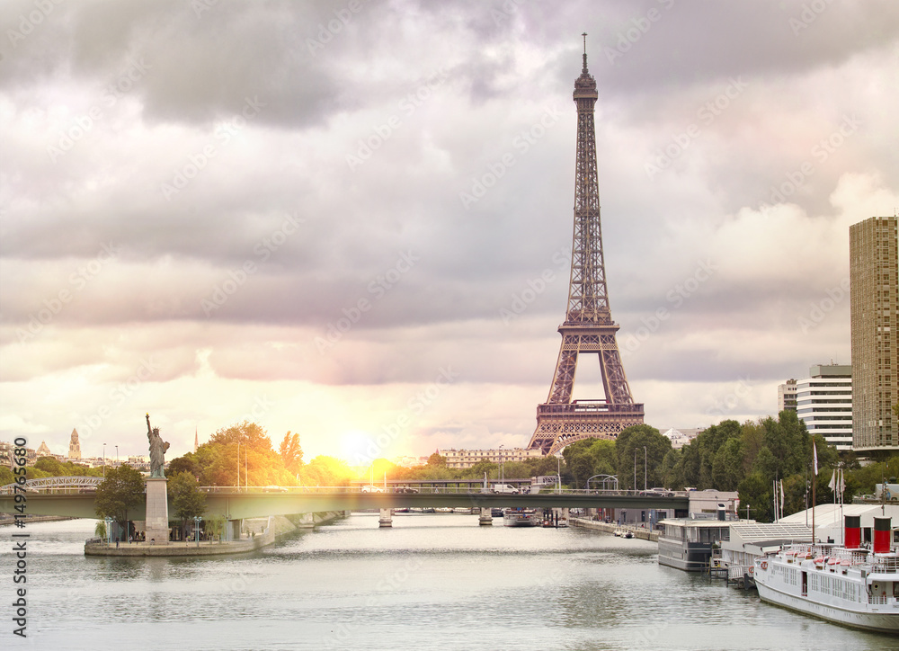 Fototapeta premium Eiffel tower sunset with clouds. Romantic sunset background. Old Monument with boats on Seine river in Paris, France.