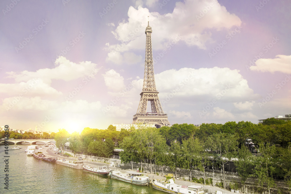 Fototapeta premium Eiffel tower sunset with clouds. Romantic sunset background. Old Monument with boats on Seine river in Paris, France.