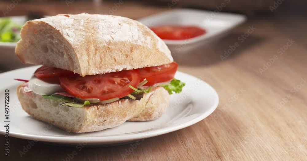 Slide shot of ciabatta sandwich with speck, mazzarella and vegetables, 4k 60fps prores footage Slide shot of ciabatta sandwich with speck, mazzarella and vegetables, 4k 60fps prores footage