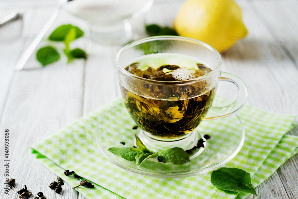Drinks, green leaf tea with sugar, mint and lemon on a white rustic wooden background Drinks, green leaf tea with sugar, mint and lemon on a white rustic wooden background
