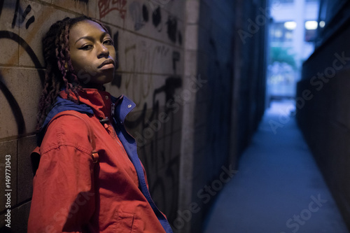 A candid portrait of a young, black woman, backlit by New York City streetlights. Shot during a Spring 2017 night in DUMBO, Brooklyn