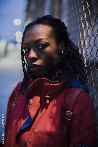 A candid portrait of a young, black woman, backlit by New York City streetlights. Shot during a Spring 2017 night in DUMBO, Brooklyn