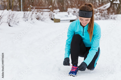 Girl tying shoelaces, winter footwear