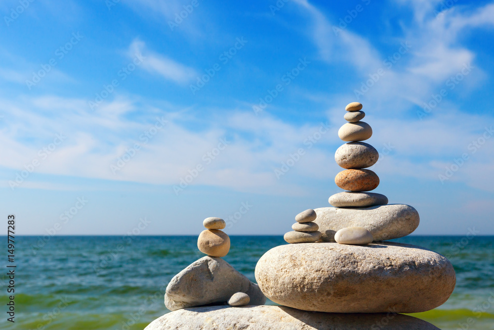 Concept of harmony and balance. Rock Zen on the background of summer sea Concept of harmony and balance. Rock Zen on the background of summer sea