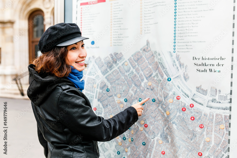 Naklejka premium Detail of young woman tourist hand pointing at street city map