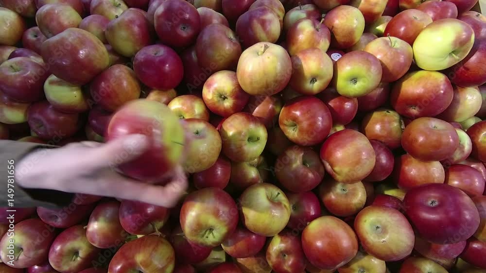 Hand takes a red apple in the store Hand takes a red apple in the store