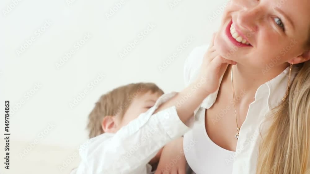 mother and son sitting at home exciting in white clothes mother and son sitting at home exciting in white clothes