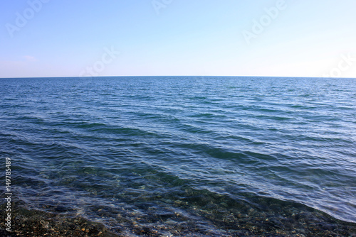 Stony shore of serene blue sea.