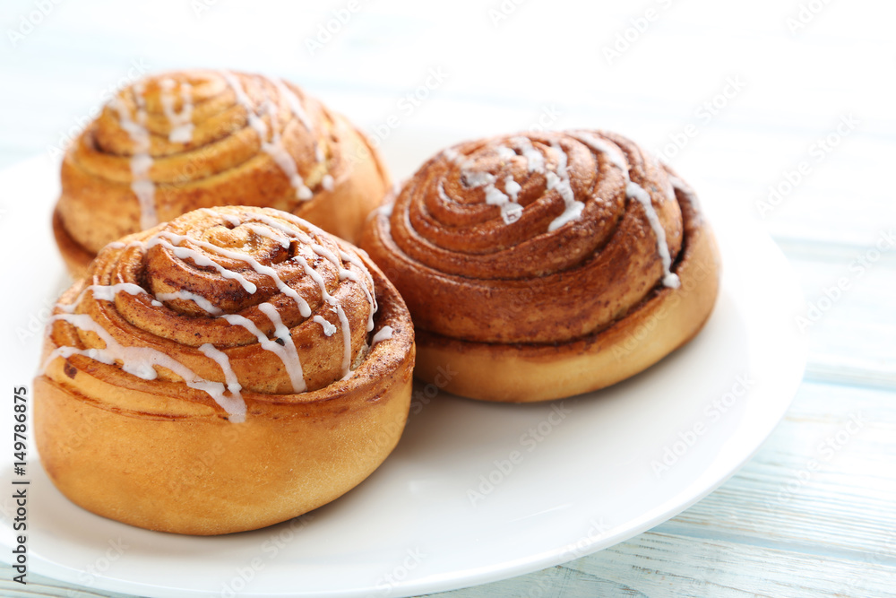 Cinnamon buns in plate on wooden table