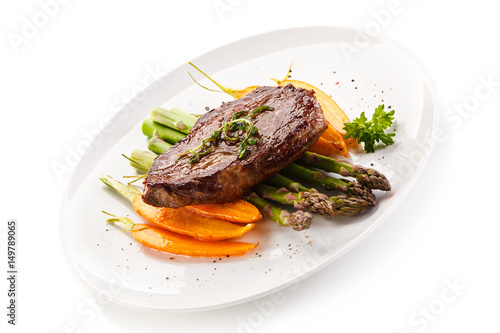 Grilled beefsteak with asparagus and carrot on white background 