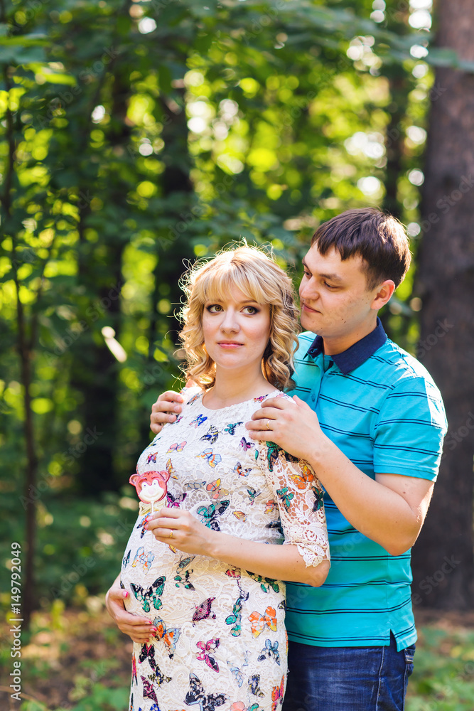 Happy young pregnant couple hugging in nature Happy young pregnant couple hugging in nature