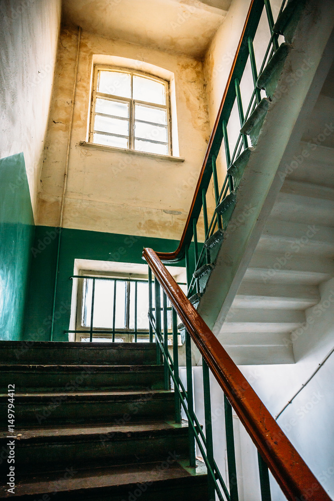 Obraz premium Inside empty old house with high ceilings, staircase, steps, window